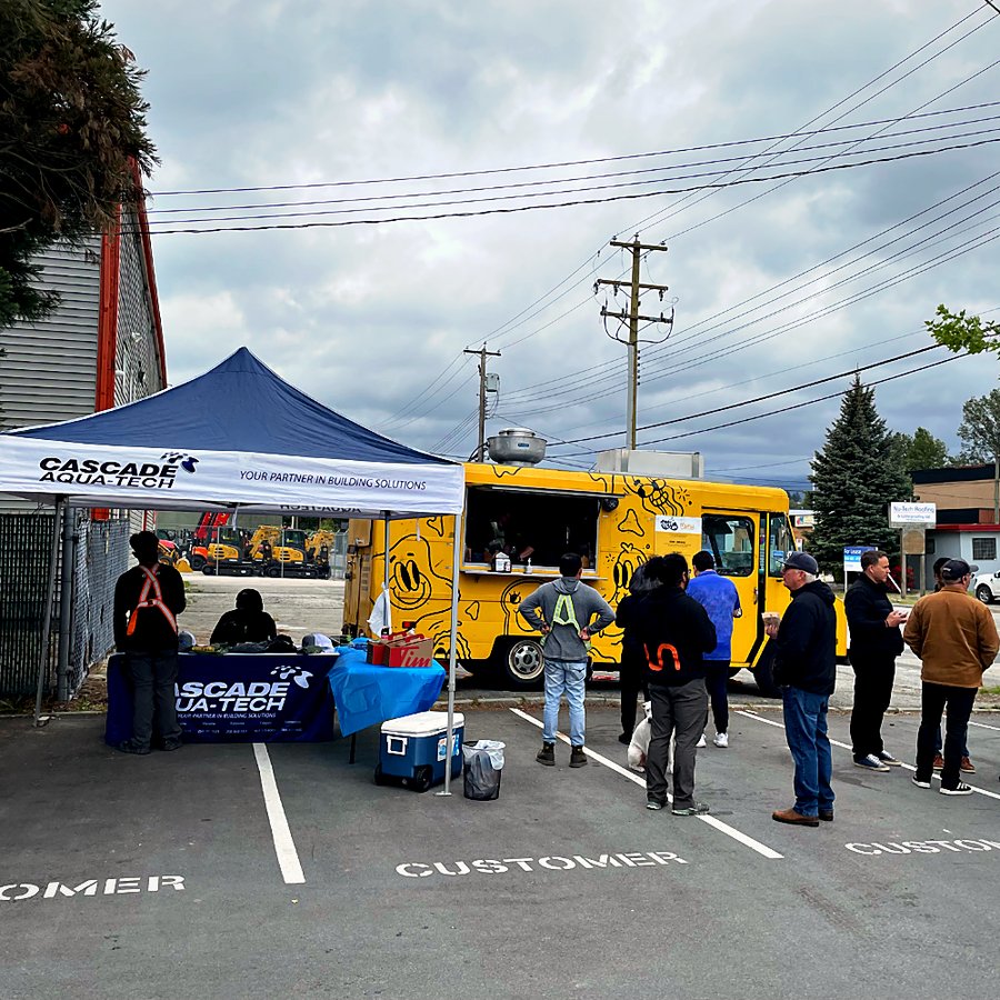 Customers lining up at the food truck beside the Cascade Aqua-Tech tent during a customer appreciation event